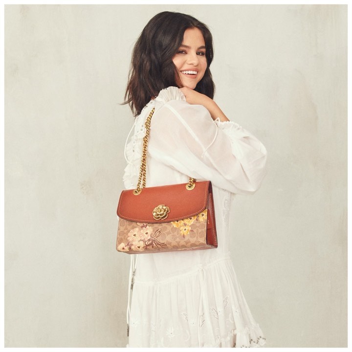 First signs of spring: a great smile, romantic ruffles and these florals. #SelenaGomez wears our newest Parker shoulder bag. #CoachNY